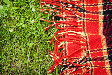 Checkered plaid for picnic on green grass. Picnic background