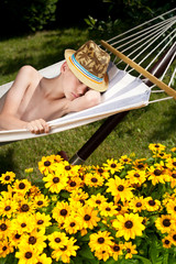 a young boy in a hammock surrounded by flowers