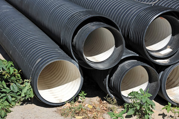 Stacked new PVC pipe on construction site