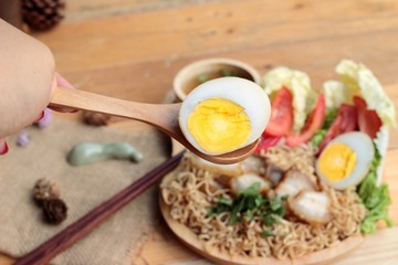 Instant noodles soup put crispy pork and egg