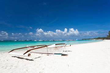 Fototapeta na wymiar Wooden boat on tropical beach with white sand