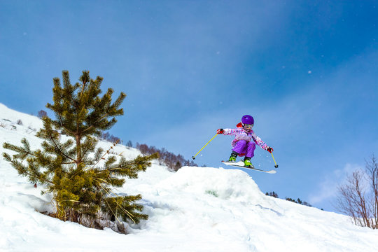Little girl skier in a jump