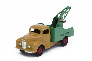 Vintage green and brown toy towing truck. Isolated against a white background.