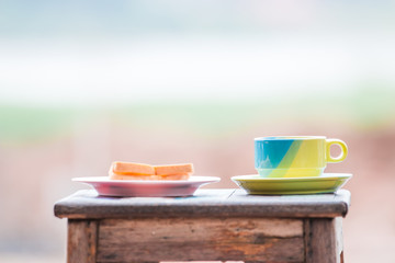 cup of coffee toast with bread on wooden chair