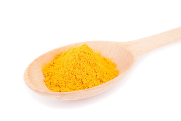 Turmeric in spoon close-up isolated on white background.