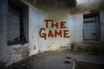 text the game on the dirty old wall in an abandoned ruined house