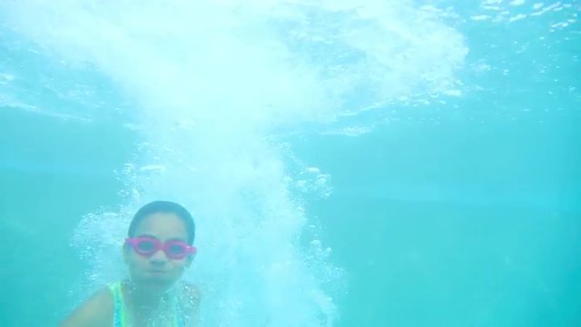 Young Hispanic Girl jumps into a pool