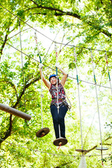 Adventure climbing high wire park - woman on course in mountain
