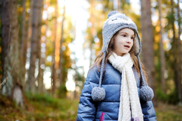 Adorable little girl hiking in forest
