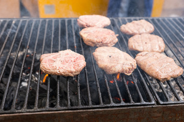 Raw Burger Patties Cooking on Smoking Grill