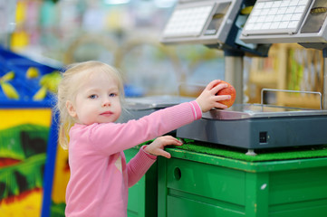 Cute little toddler girl shopping in a food store