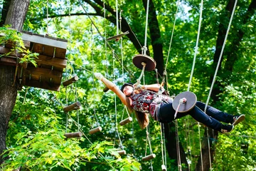 Deurstickers Adventure climbing high wire park - woman on course in mountain © davit85