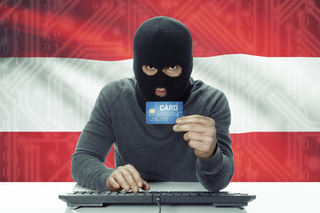 Dark-skinned hacker with flag on background holding credit card - Austria