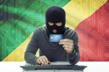 Dark-skinned hacker with flag on background holding credit card - Congo-Brazzaville