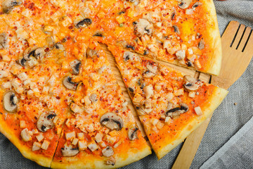 Delicious homemade pizza with cheese and mushrooms on a wooden