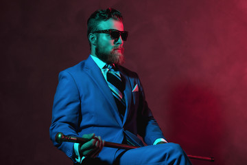 Stylish gentleman with a cane and sunglasses