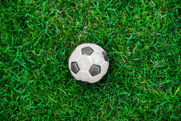 Old and classic Soccer ball or football ball on green field