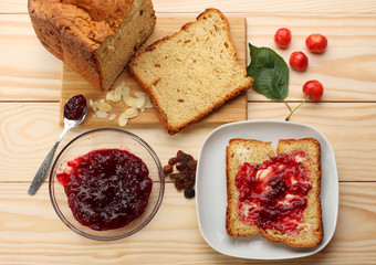 Sweet bread  with raisins and almonds, butter and cherry jam