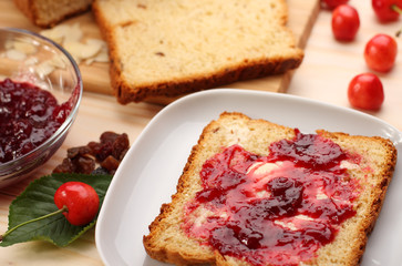 Sweet bread  with raisins and almonds, butter and cherry jam
