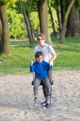 Fototapeta premium Fun on the swing, the boys together on the playground 