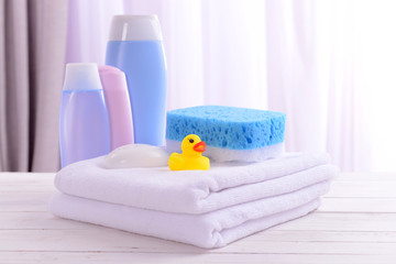 Baby accessories for bathing on table on light background