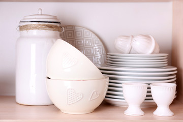 Fototapeta na wymiar Kitchen utensils and tableware on wooden shelf