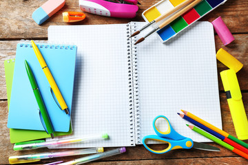Notebook and bright school stationery on old wooden table
