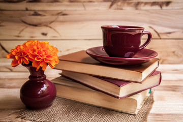 cup with orange flowers on a wooden background