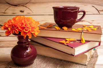 cup with orange flowers on a wooden background