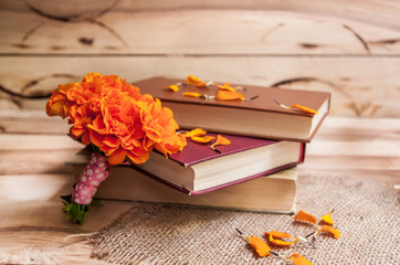 Flowers. Beautiful yellow chrysanthemum in a vintage vase. Old books on a wooden background.