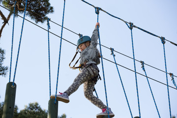 teenager climbing a rope park, Girl climbing in adventure park 

