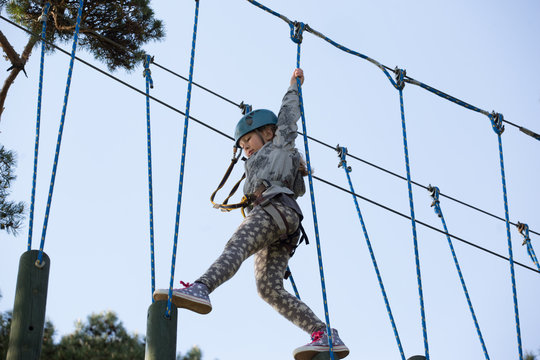 teenager climbing a rope park, Girl climbing in adventure park 
