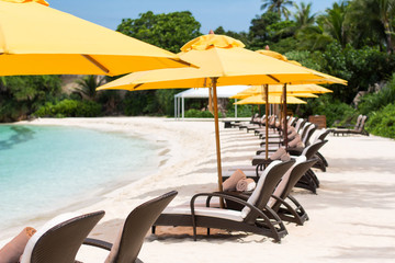 Sun umbrellas and beach chairs on tropical beach