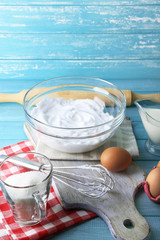 Whipped egg whites for cream on color wooden background