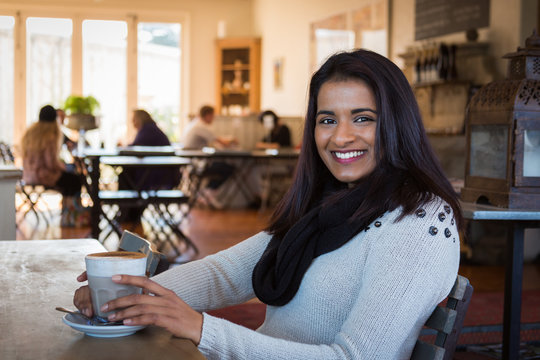 Indian woman with coffee at a cafe