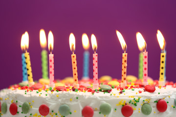 Birthday cake with candles on purple background