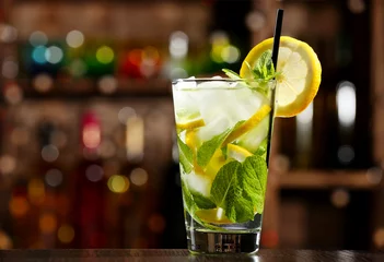 Fototapeten Glass of cocktail in bar on bright blurred background © Africa Studio