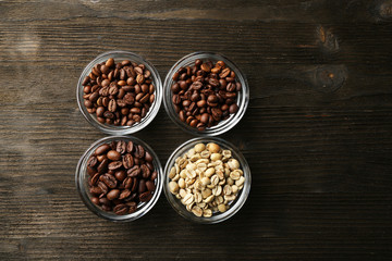 Coffee beans in saucers on wooden background