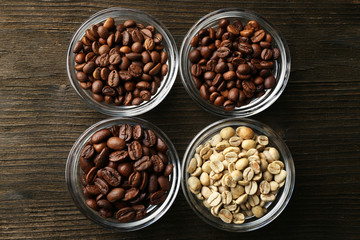 Coffee beans in saucers on wooden background