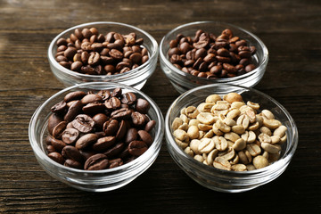Coffee beans in saucers on wooden background