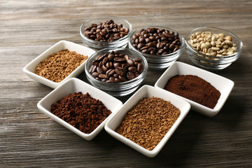 Coffee beans in saucers on wooden background