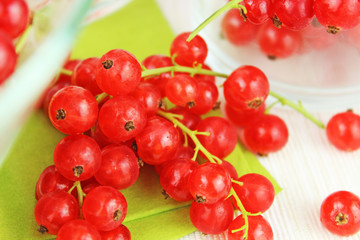 Johannisbeeren in Schale aus Glas und auf Esstisch auf grüner Serviette