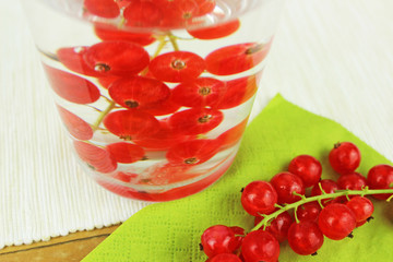 Johannisbeeren in Wasserglas und auf Esstisch