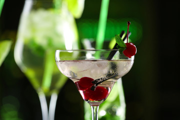 Glasses of cocktails on bar background