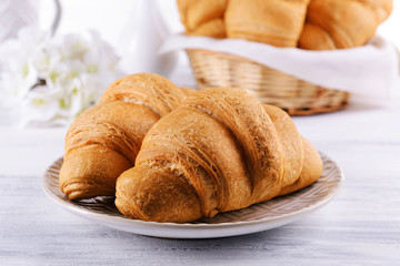 Delicious croissants on plate on table close-up