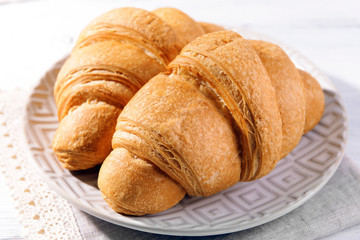 Delicious croissants on plate on table close-up