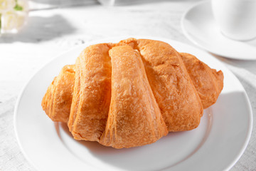 Delicious croissants on plate on table close-up