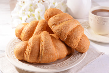 Delicious croissants on plate on table close-up