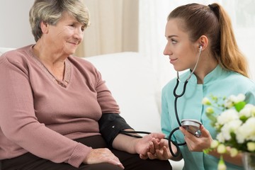 Young medic taking blood pressure