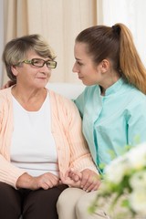 Elderly female sitting beside nurse